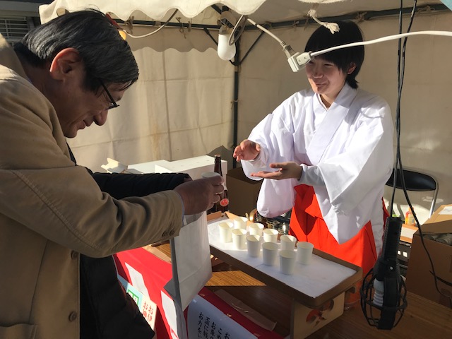 御神酒を渡すお巫女さん